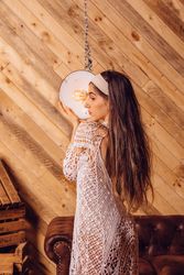 Young woman posing between ceiling lamps