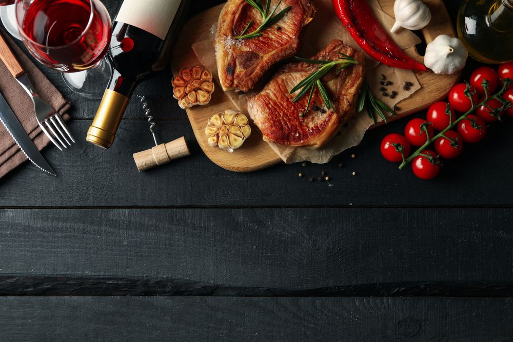 Composition with fried steaks and wine. Grilled food