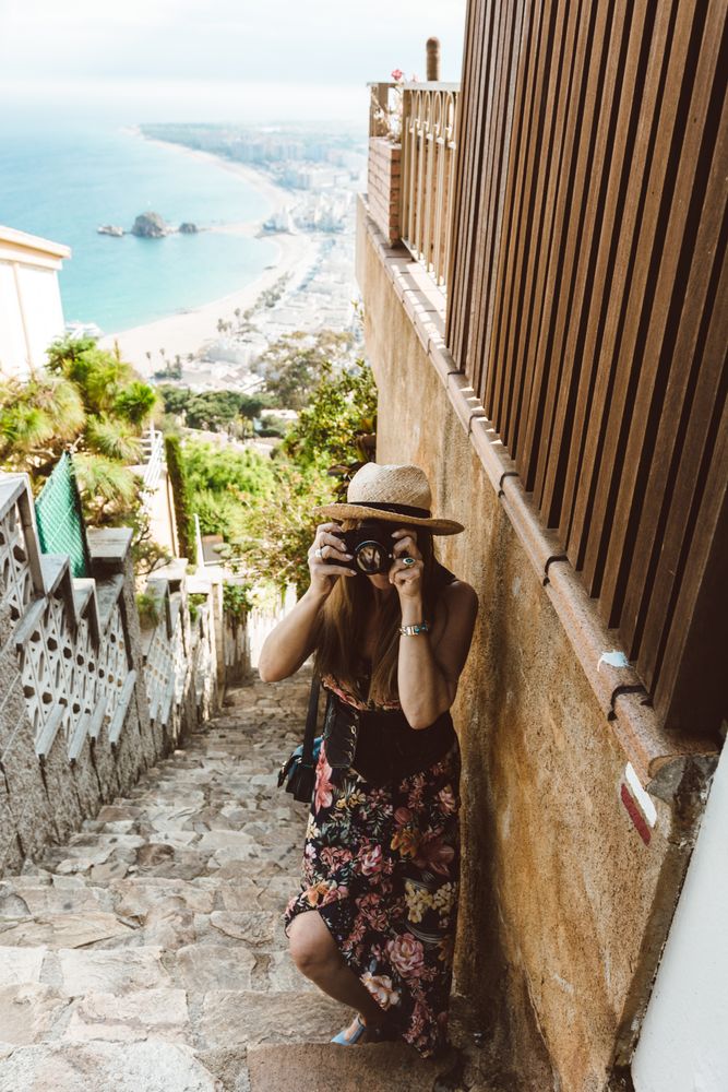 Stylish woman picturing coast from stairway