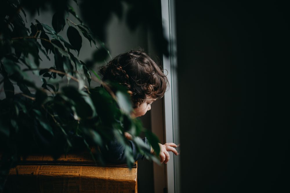 Side view of toddler looking out window
