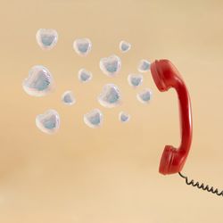 Ear piece of red vintage phone with hearts