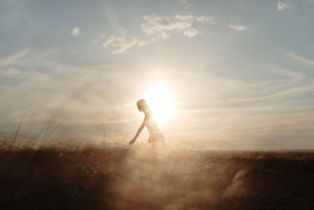 Side view of young woman standing in an open field