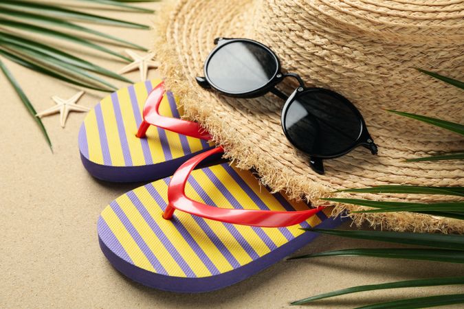Summer vacation accessories on sea sand background, close up