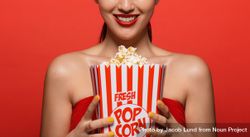 Close up of woman holding popcorn bucket 5zE1k0