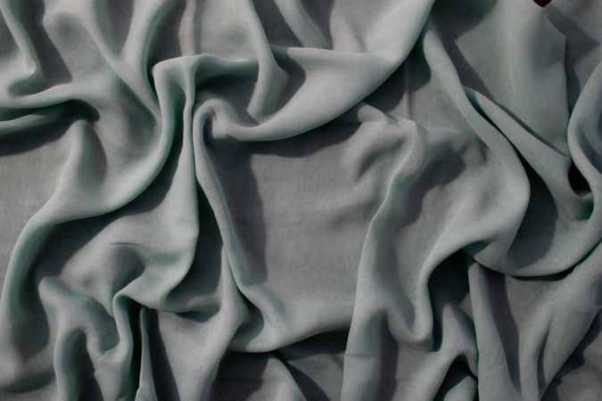 Nude green fabric wavy crumpled background texture with copy space.