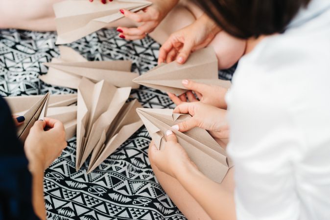 Group of women making paper planes