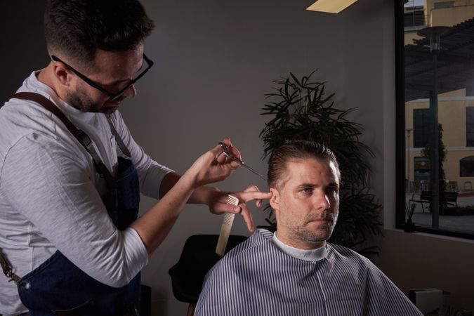 Barber cutting hair of client