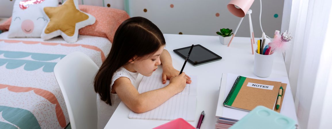 Girl doing homework in her bedroom
