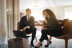 Man and women working together around a laptop in a modern office