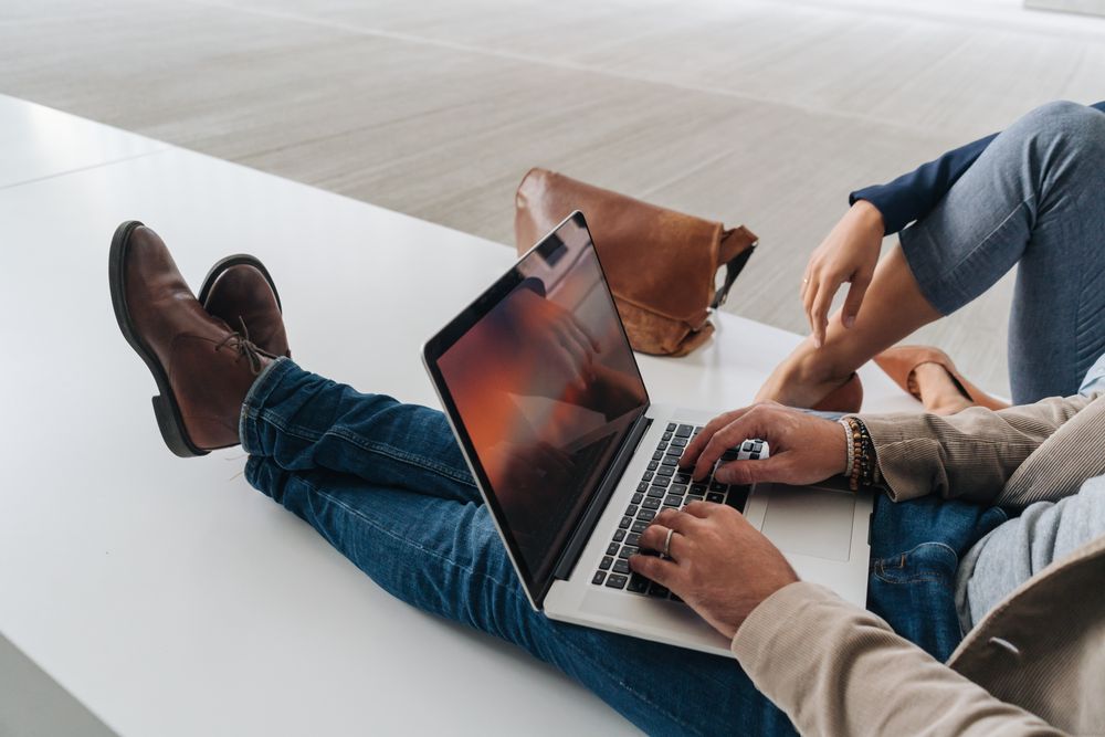 Crop people using laptop on street