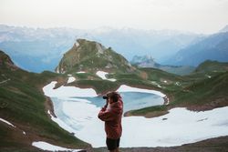 Unrecognizable man taking photo of mountain landscape