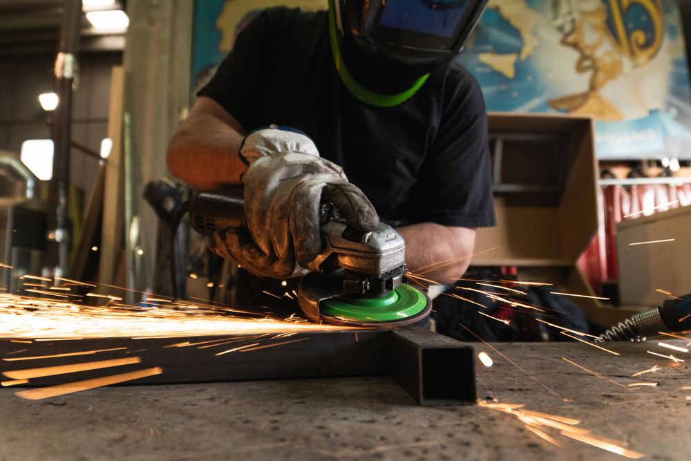 Male worker using electric grinder in workshop