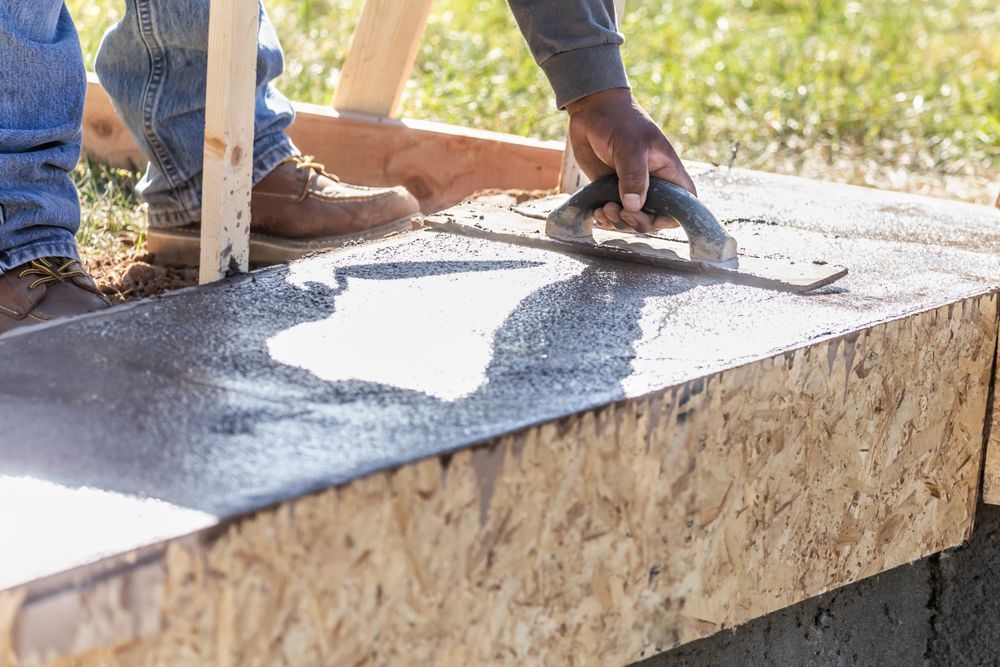 Construction Worker Using Wood Trowel On Wet Cement Forming Coping Around New Pool