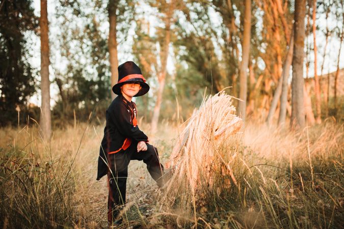 Boy in halloween costume with long grass in the forest