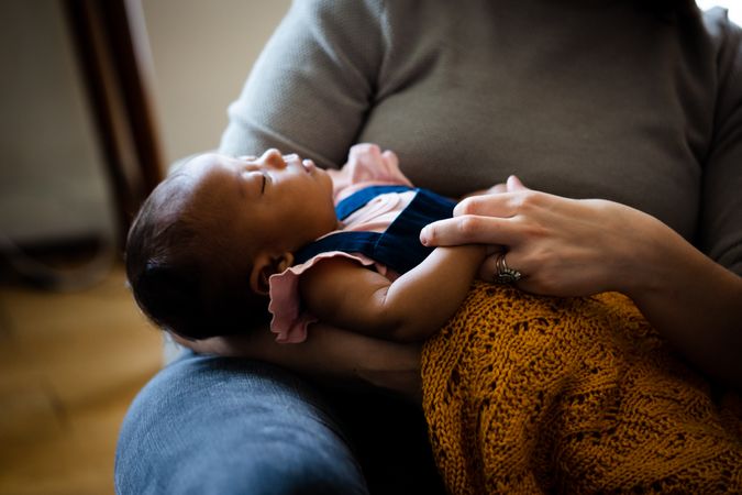 Close up of baby sleeping on mother’s lap