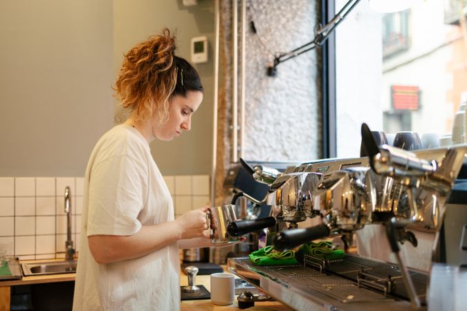 Young barista steaming milk
