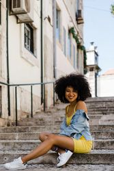 Stylish female sitting in stairs with railing outdoors
