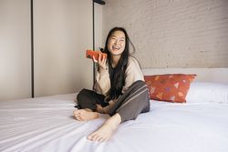 Young female using a phone on bed