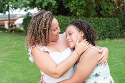 Portrait of young mother with teenage daughter in park