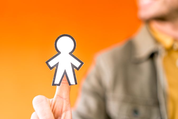 Smiling man holding funny paper toy