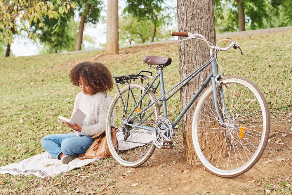 Black female reading book in nature