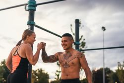 interracial couple training outdoors, fist bumping