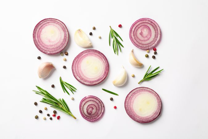 Flat lay composition with red onion rings and spices on neutral background