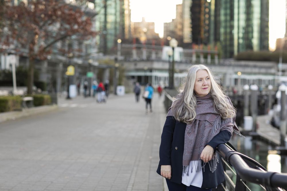 Woman with gray hair leaning on a railing