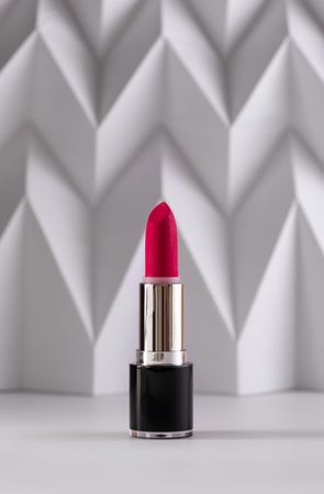 Pink lipstick on raised chevron. Product and make up contemporary concept
