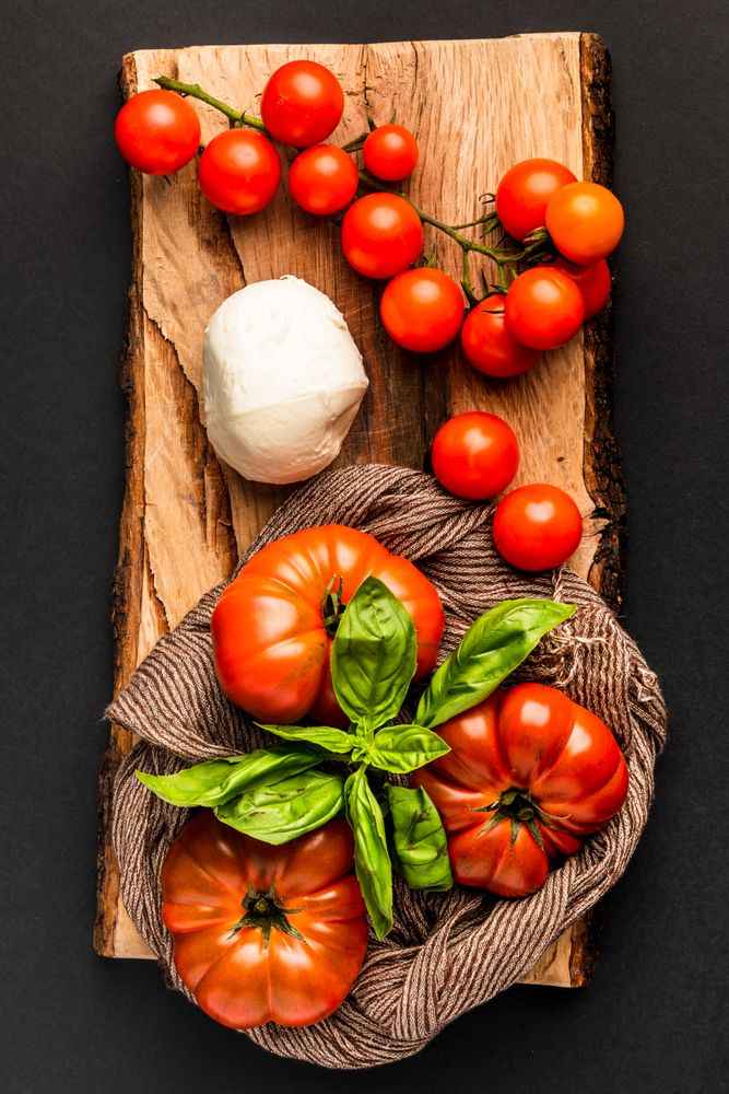 Tomatoes, mozzarella and napkin on wooden board