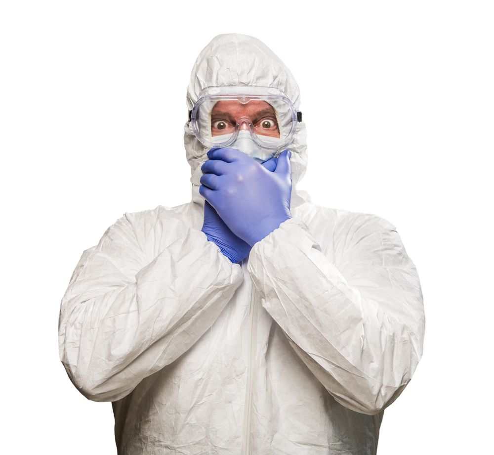 Man Covering Mouth With Hands Wearing HAZMAT Protective Clothing Isolated On A Plain Background.