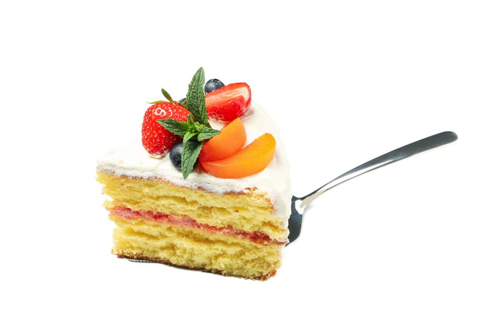 Shovel with berry cream cake isolated on plain background