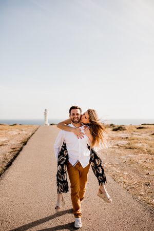 Happy lovers having fun on path from sea