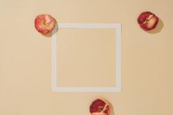 Minimal sunlit fruit composition with sand color background and sharp shadows