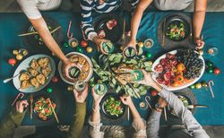 Group toasting at festive table with candy canes and roasted pears