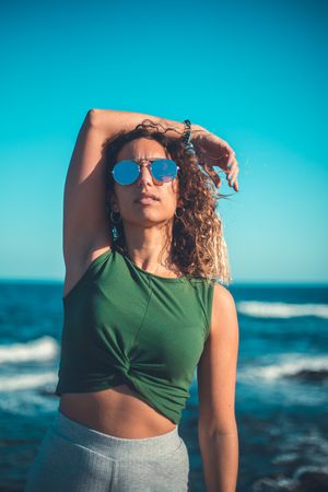 Stylish woman standing near sea