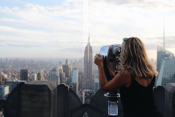 Woman looking at the city through binocular