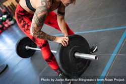 Woman adding weight to a bar for weightlifting 5Q2QvE