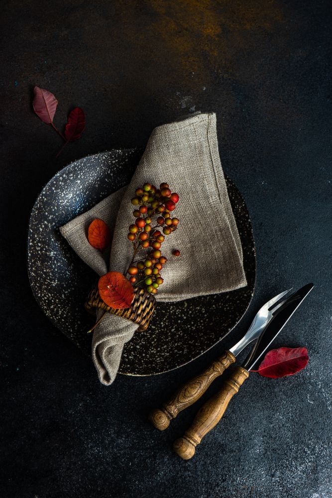 Top view of autumnal table setting with amber leaves