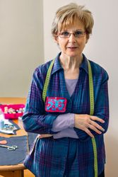 Mature dressmaker posing with sewing materials