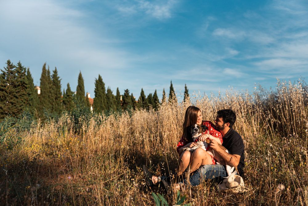 Happy couple with friendly cute dog resting outdoors