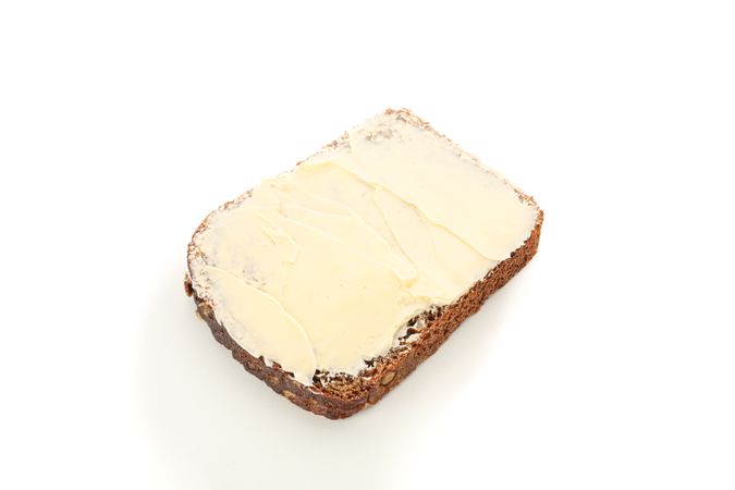 Rye bread piece with butter isolated on blank background. Bakery products