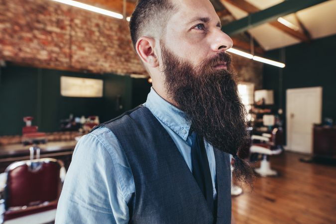 Close up of serious male barber with long beard