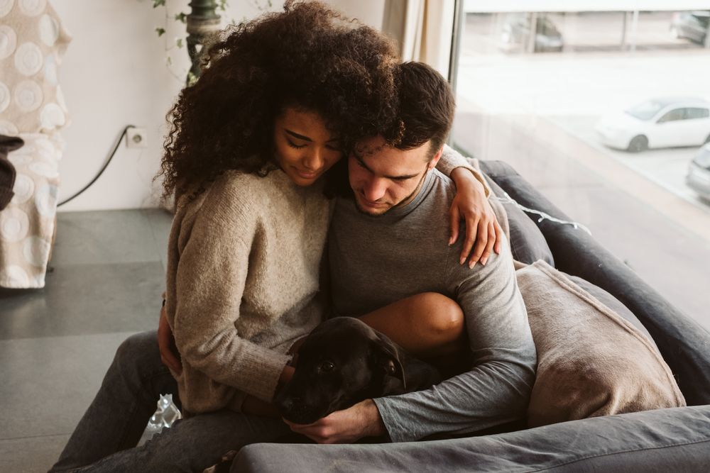Multiethnic couple with dog on couch