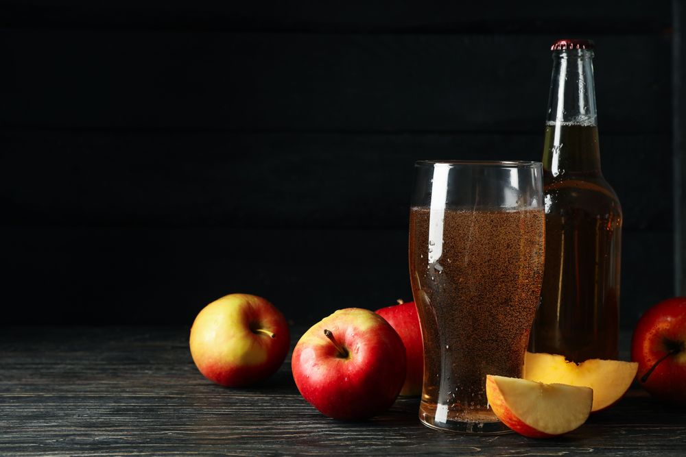 Composition with cider and apples on wooden background