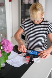 Focused woman putting pills in pill box