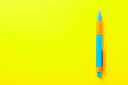 Pen on yellow background, space for text