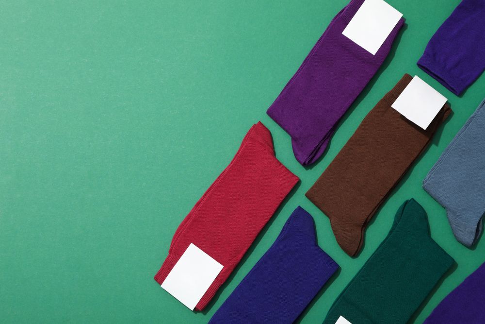 Socks with blank label on green background, space for text