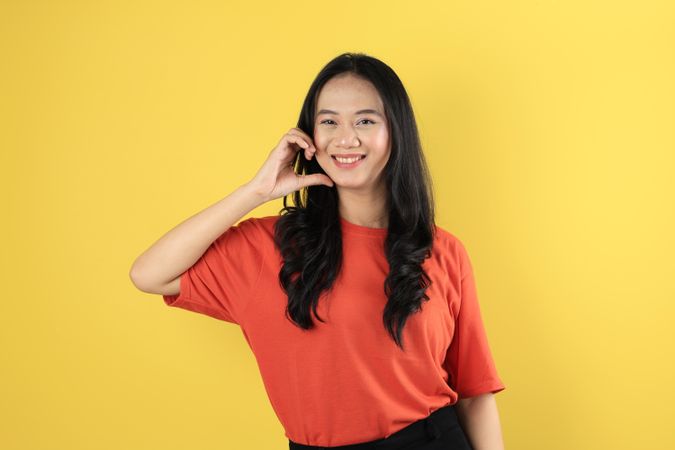 Portrait of Young Asian Indonesian Female making Love Heart Sign on Her Cheek