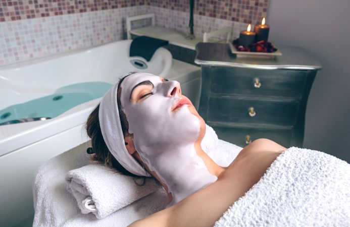 Woman lying in spa with face mask